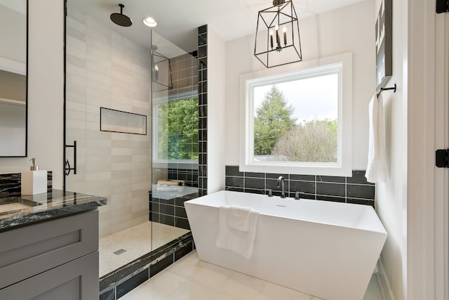 bathroom with an inviting chandelier, shower with separate bathtub, tile floors, and vanity