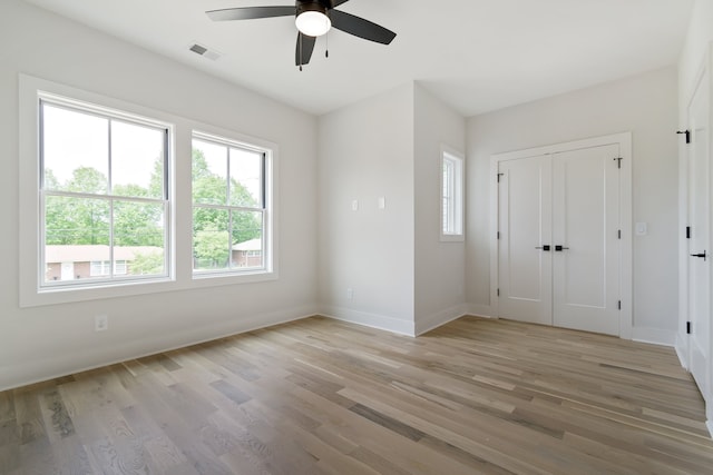 spare room with light hardwood / wood-style flooring, ceiling fan, and a wealth of natural light