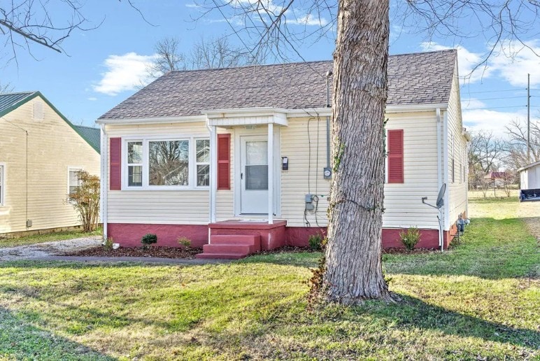 bungalow-style house featuring a front lawn