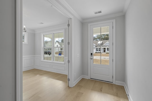 doorway to outside featuring light hardwood / wood-style flooring, crown molding, and a healthy amount of sunlight