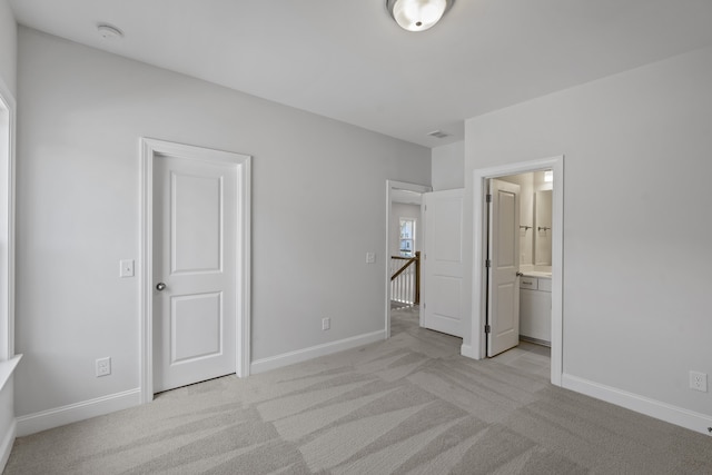 unfurnished bedroom with light carpet and ensuite bathroom