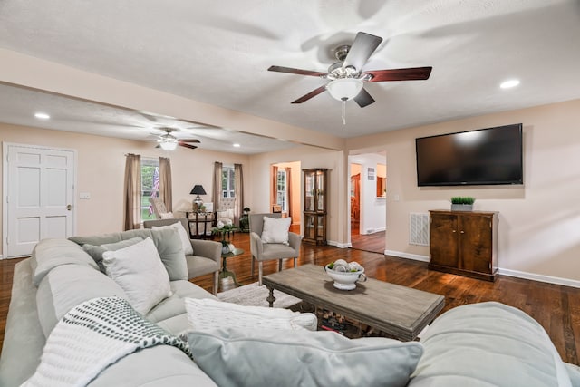 living room with ceiling fan and dark hardwood / wood-style flooring