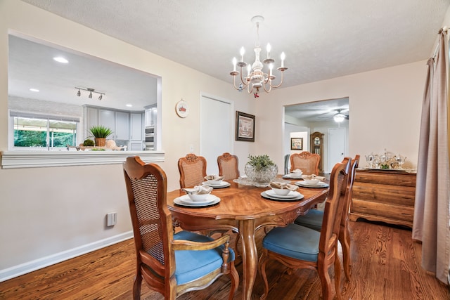 dining space with track lighting, a textured ceiling, dark hardwood / wood-style floors, and ceiling fan with notable chandelier