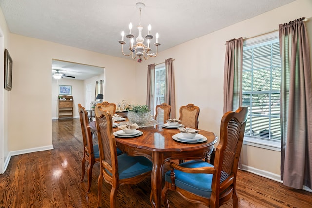 dining area featuring dark hardwood / wood-style flooring and ceiling fan with notable chandelier