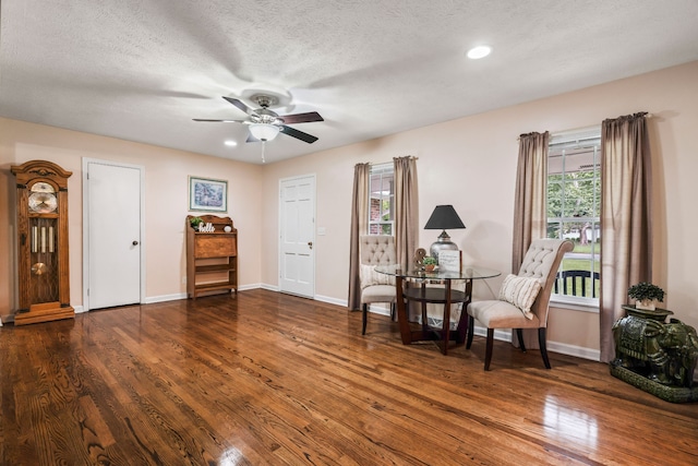 living area featuring a textured ceiling, ceiling fan, and dark hardwood / wood-style floors