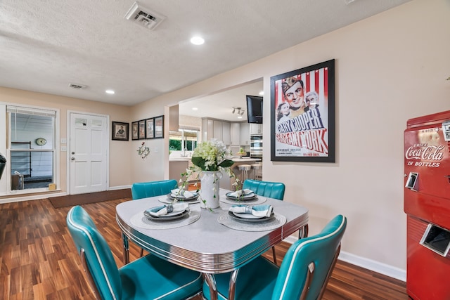 dining area with dark hardwood / wood-style flooring and a textured ceiling