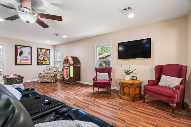 living room featuring ceiling fan and light hardwood / wood-style floors