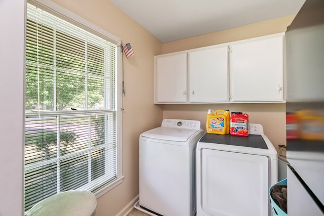 laundry area featuring washing machine and clothes dryer and cabinets