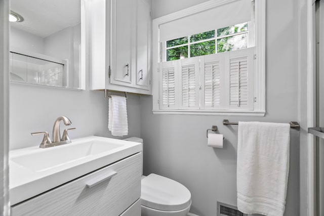 bathroom with toilet and large vanity