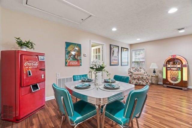 dining space featuring a textured ceiling and wood-type flooring