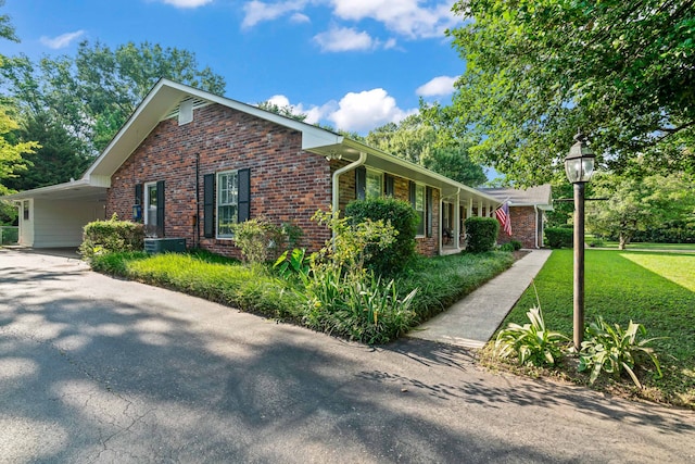 view of side of property featuring a lawn and a carport