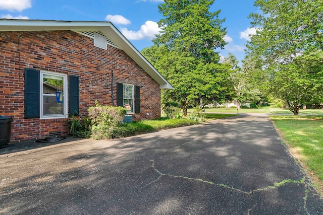 view of side of home with a yard