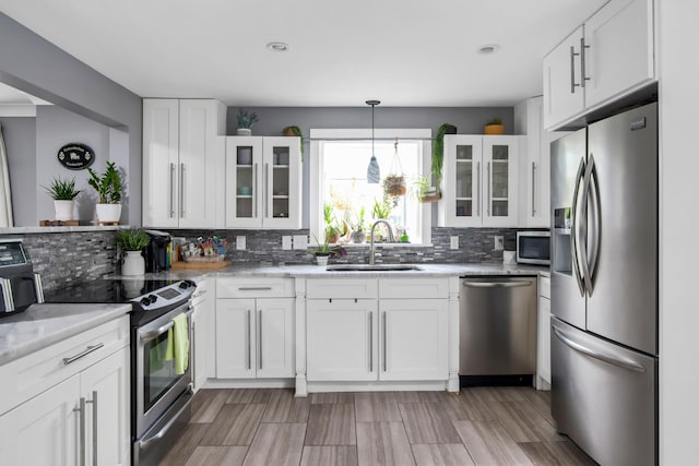 kitchen with white cabinets, tasteful backsplash, and stainless steel appliances