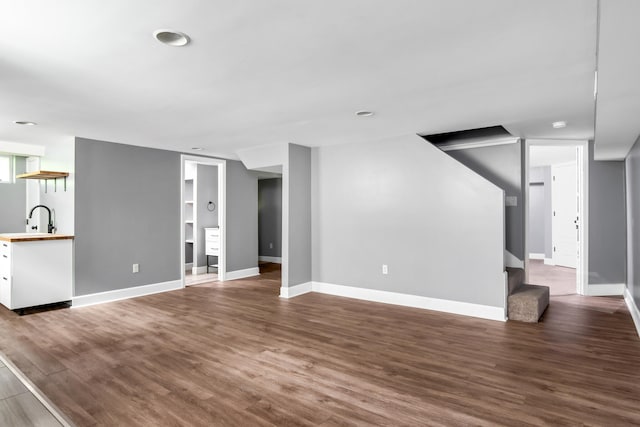 unfurnished living room featuring dark wood-type flooring and sink