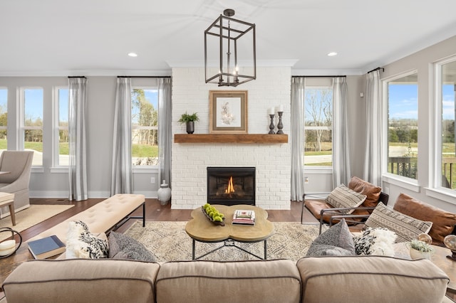 living room featuring ornamental molding, plenty of natural light, a fireplace, and light hardwood / wood-style floors