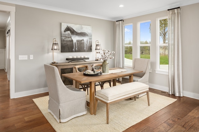 dining space with dark hardwood / wood-style flooring and ornamental molding