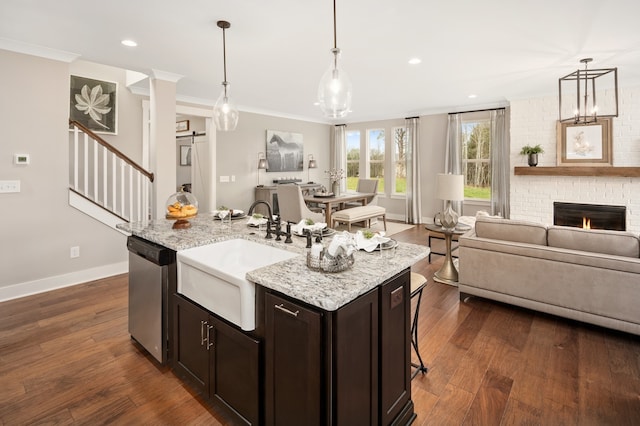 kitchen with stainless steel dishwasher, ornamental molding, dark wood-type flooring, and decorative light fixtures