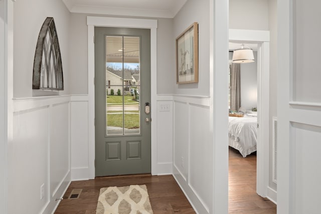 entryway featuring ornamental molding and dark wood-type flooring