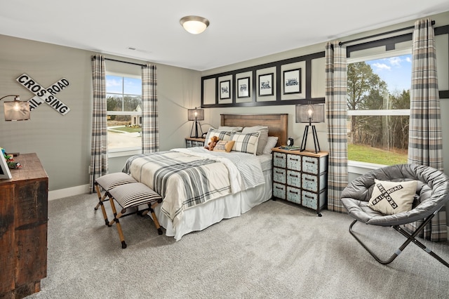 bedroom with light colored carpet and multiple windows