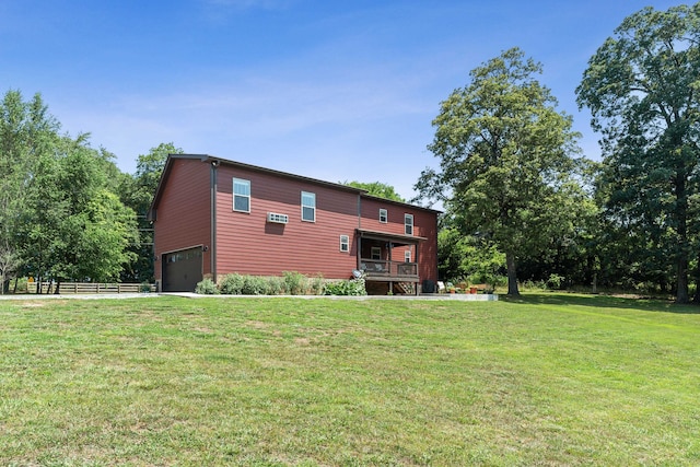 rear view of house featuring a yard and a garage