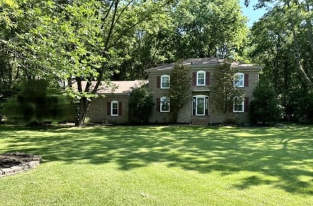 colonial house featuring a front lawn