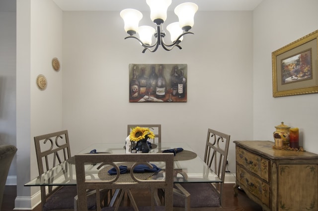 dining area featuring dark hardwood / wood-style floors and an inviting chandelier