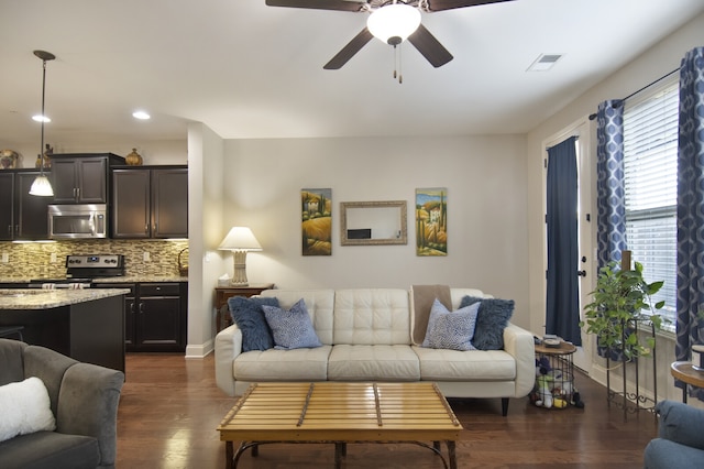 living room featuring dark hardwood / wood-style floors and ceiling fan