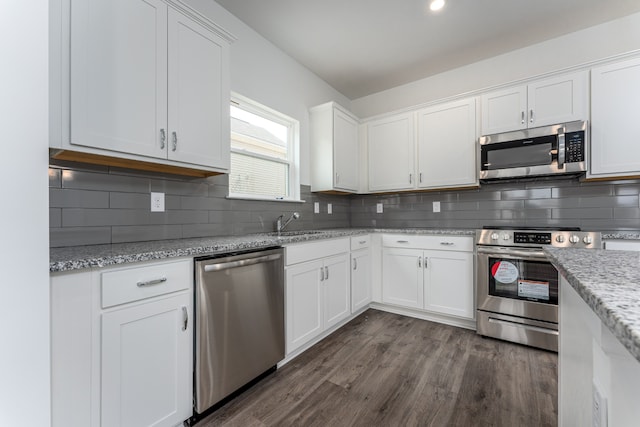 kitchen with backsplash, dark wood-type flooring, and stainless steel appliances