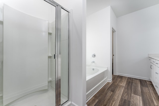 bathroom featuring independent shower and bath, wood-type flooring, and vanity