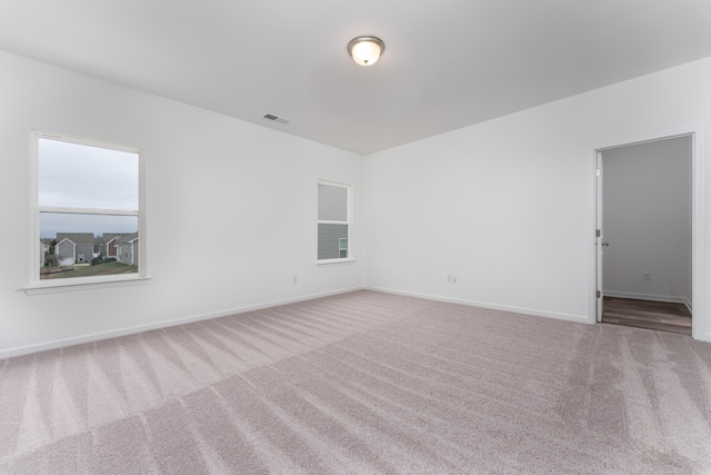 unfurnished room featuring a healthy amount of sunlight and carpet flooring