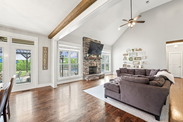 living room featuring high vaulted ceiling, ceiling fan, beamed ceiling, a stone fireplace, and dark wood-type flooring