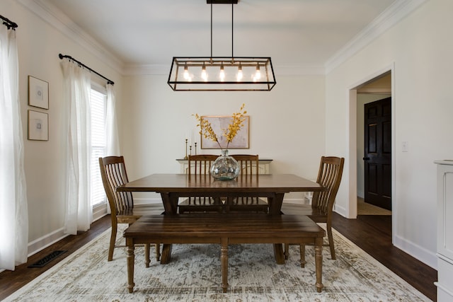 dining area featuring a chandelier, dark hardwood / wood-style floors, and ornamental molding