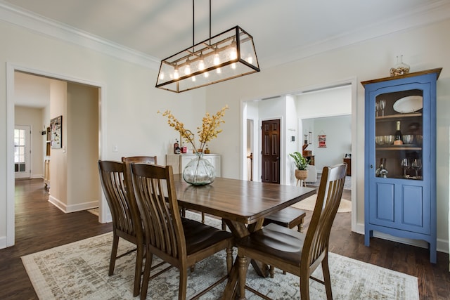 dining room featuring an inviting chandelier, dark wood-type flooring, and ornamental molding