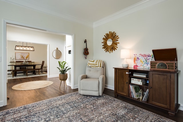 sitting room with dark hardwood / wood-style flooring, a notable chandelier, and ornamental molding