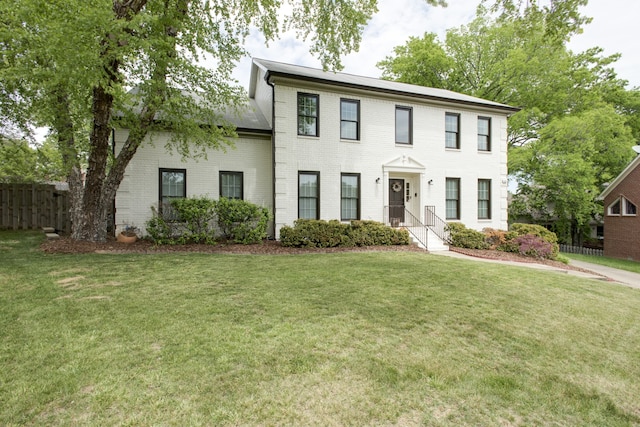 colonial house featuring a front lawn