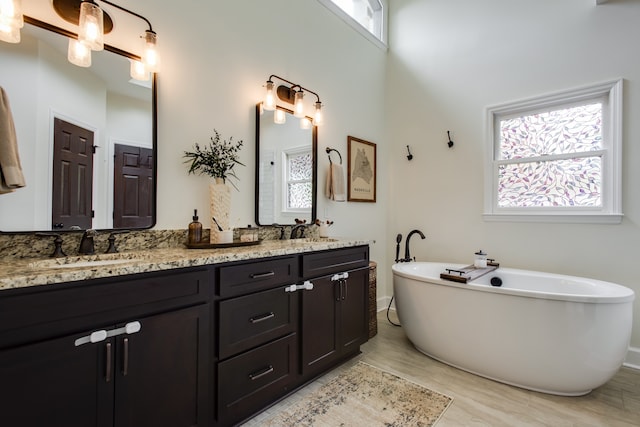 bathroom with dual bowl vanity and a bathtub