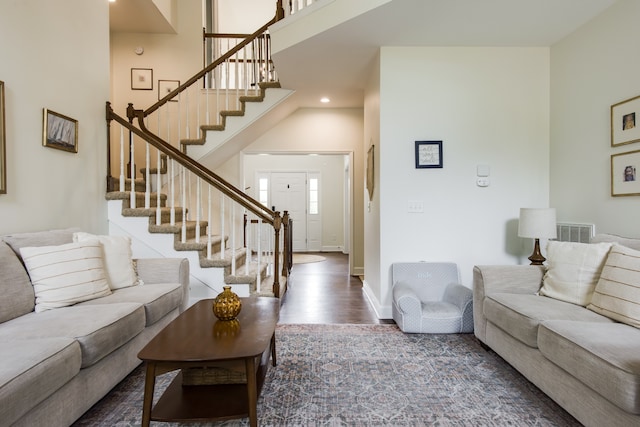 living room featuring dark hardwood / wood-style floors and a towering ceiling