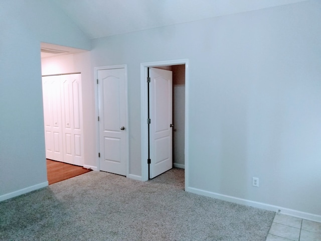 empty room featuring lofted ceiling and light carpet