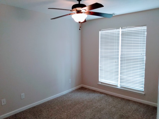 spare room featuring ceiling fan and dark colored carpet