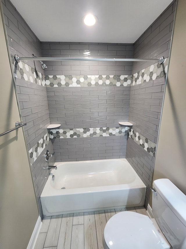 bathroom featuring toilet, tiled shower / bath, and hardwood / wood-style floors