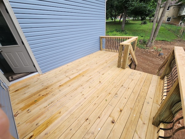 wooden terrace featuring a lawn