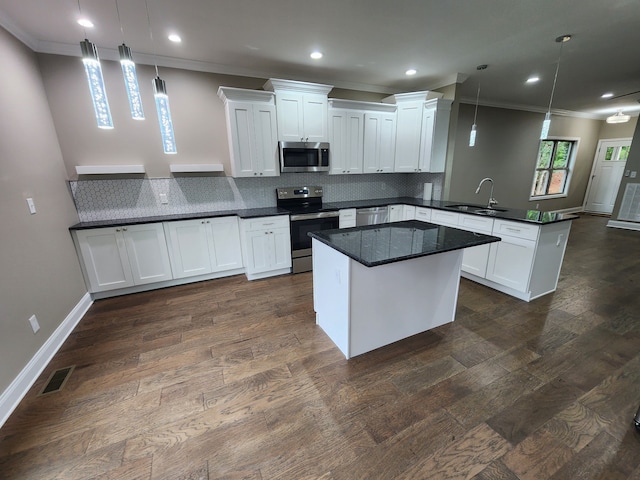 kitchen featuring white cabinets, appliances with stainless steel finishes, decorative light fixtures, and dark hardwood / wood-style flooring