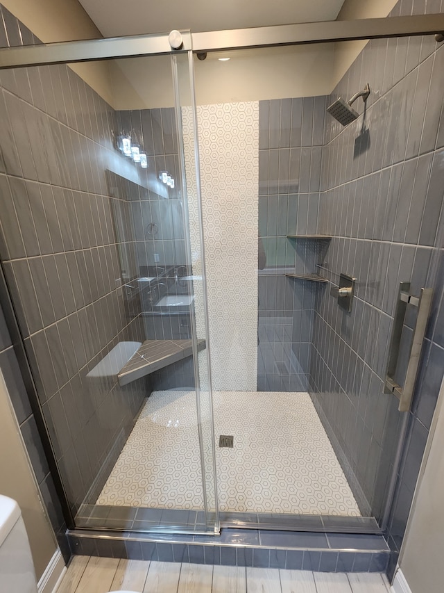 bathroom with toilet and an enclosed shower