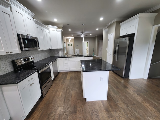 kitchen with dark hardwood / wood-style floors, ceiling fan, ornamental molding, appliances with stainless steel finishes, and backsplash