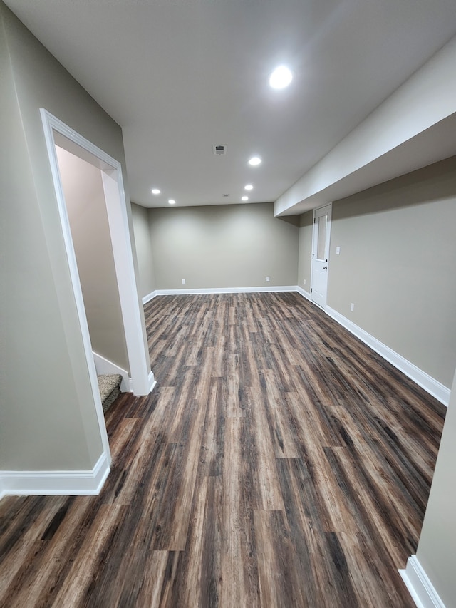 basement with dark hardwood / wood-style floors