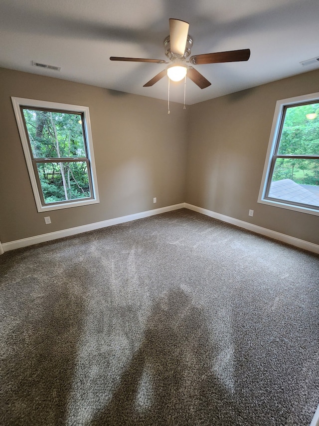 unfurnished room with ceiling fan and carpet