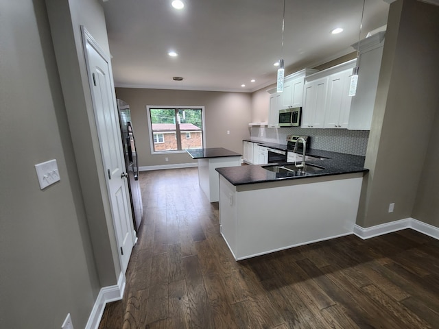 kitchen featuring tasteful backsplash, dark hardwood / wood-style floors, stainless steel appliances, kitchen peninsula, and hanging light fixtures