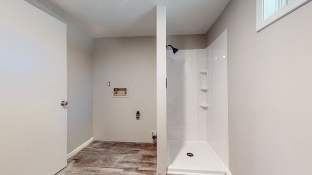 bathroom with a textured ceiling, walk in shower, and hardwood / wood-style flooring