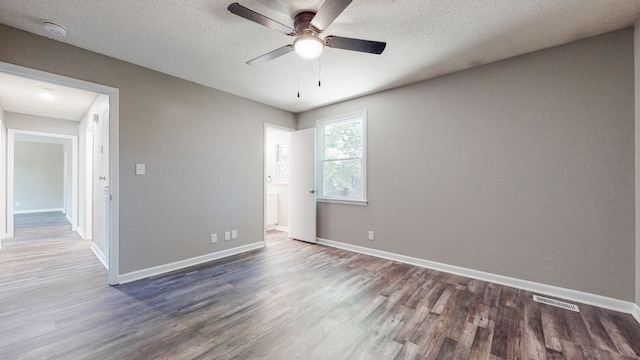 unfurnished room with a textured ceiling, dark hardwood / wood-style floors, and ceiling fan