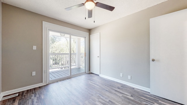 empty room with ceiling fan, hardwood / wood-style floors, and a textured ceiling